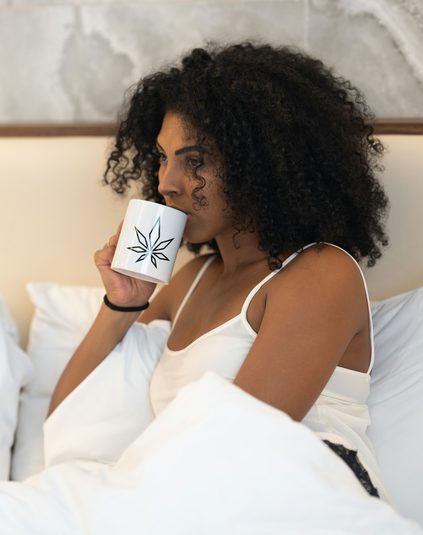Woman relaxing at home with a warm drink, representing everyday breast wellness and self-care